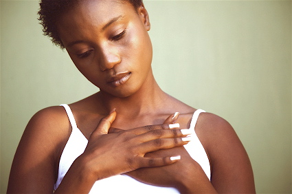 African woman with hands crossed over heart